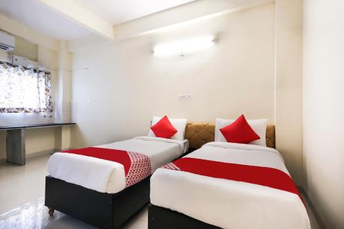 Hotel Aashirwad في إندوري: سريرين يجلسون بجانب بعض في غرفة