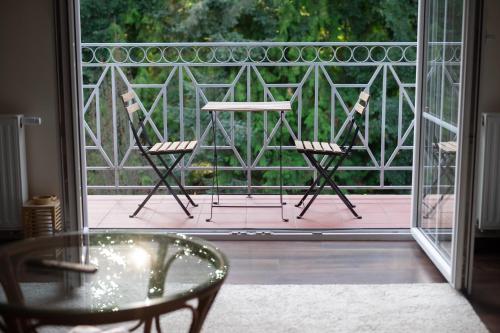 a patio with two chairs and a table on a balcony at NIENOVO - Apartament Kórnik niedaleko jeziora i widok na Arboretum in Kórnik