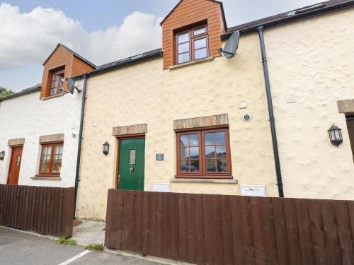 a house with a green door and a fence at Bwthyn Canol in Haverfordwest