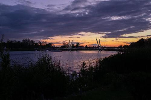 a body of water with a sunset in the background at NIENOVO - Apartament Kórnik niedaleko jeziora i widok na Arboretum in Kórnik