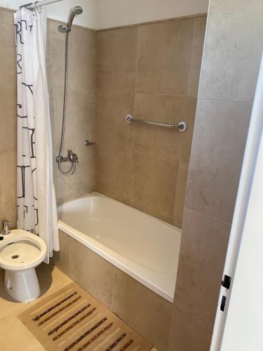 een badkamer met een bad en een toilet bij Monoambiente Céntrico único in Puerto Madryn