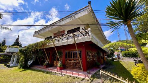 a red and white building with a palm tree at Chakra Tavern in Bedugul