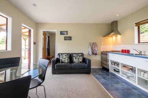a living room with a glass table and a couch at Hopewell Lodge in Kenepuru Sounds
