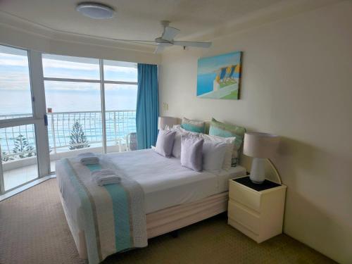 a bedroom with a bed with a view of the ocean at Burleigh Surf Apartments in Gold Coast