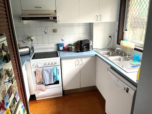 a small kitchen with a stove and a sink at Hill Haven in Brisbane