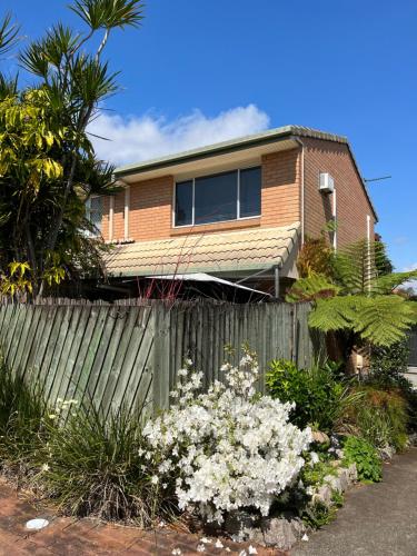 ein Haus mit einem Zaun und Blumen davor in der Unterkunft Hill Haven in Brisbane