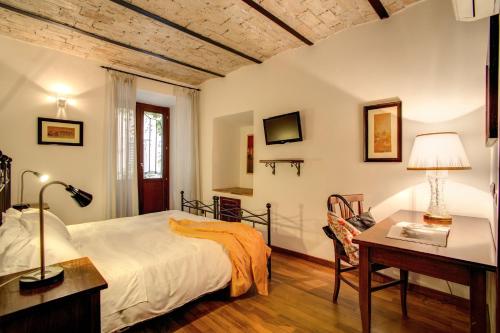 ローマにあるレジデンツァ ドミツィアのベッドルーム1室(ベッド1台、テーブル、デスク付)
