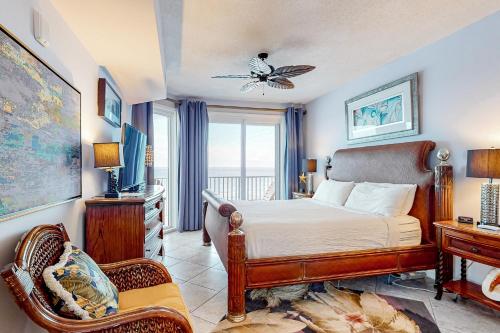 a bedroom with a bed and a chair and a window at Windemere in Perdido Key