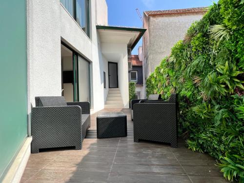 a row of wicker chairs sitting on a patio at RIACENTRUM - Smart Residence in Aveiro