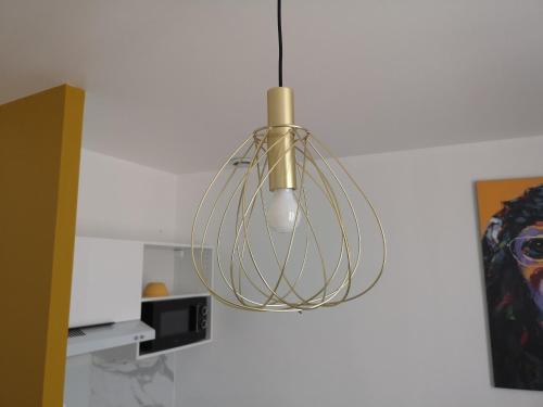 une lumière abondante suspendue au plafond dans une pièce dans l'établissement STUDIO COSY- CHALEUREUX- QUARTIER CALME- Wifi, à Saint-Quentin