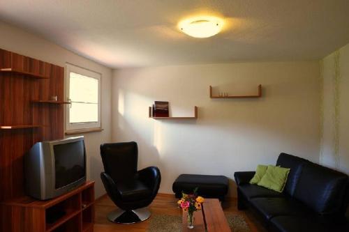 sala de estar con sofá y TV en Ferienwohnung Himmelsbach, en Gengenbach