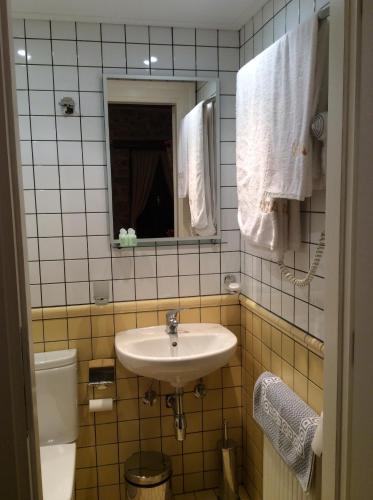 a bathroom with a sink and a toilet and a mirror at Oihalia Guesthouse in Fidhákia