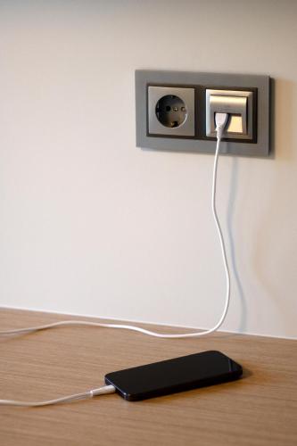 a black device with a cord plugged into a wall at RIACENTRUM - Smart Residence in Aveiro