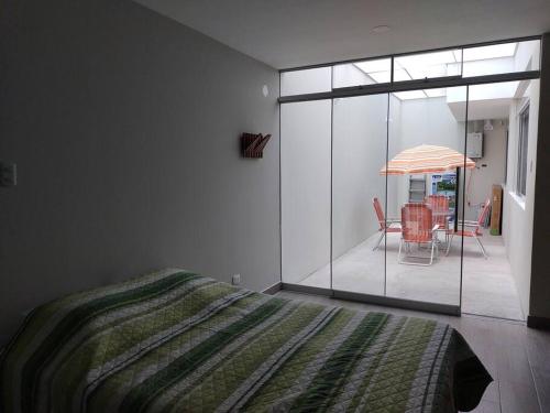 1 dormitorio con 1 cama y 1 mesa con sombrilla en SAMANA WASI la punta, en Punta de Bombón