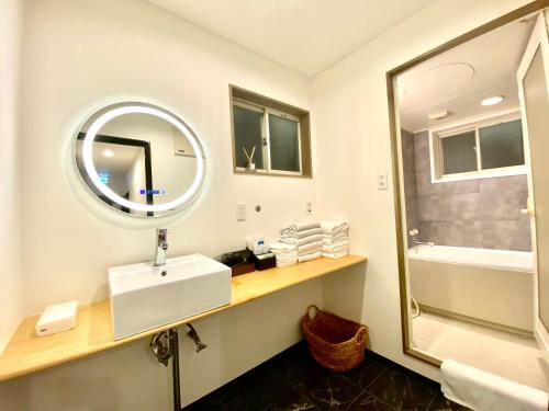 uma casa de banho com um lavatório e um espelho em 外宮前別邸　星凪庵 em Ise