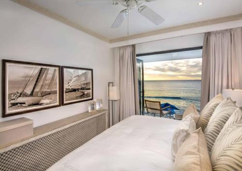 a bedroom with a bed with a view of the ocean at Nirvana Barbados by MC Luxury Rentals in Saint James