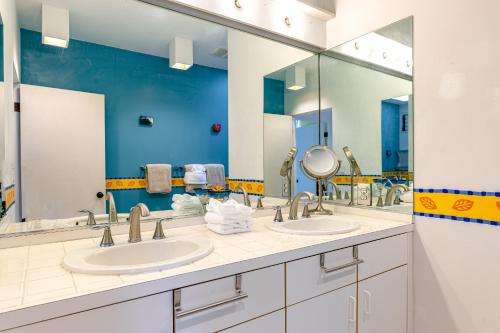 a bathroom with two sinks and two mirrors at The H-House in Waikoloa
