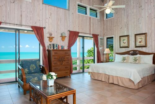 a bedroom with a bed and a view of the ocean at Sunset Point Oceanfront Villa in Providenciales