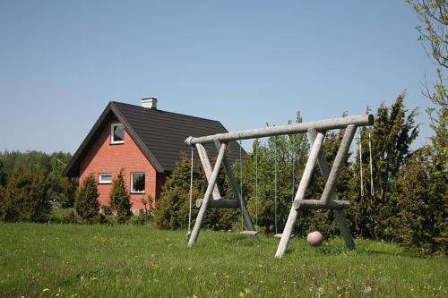 a swing set in a field in front of a house at Pruuli Holiday Farm in Sõru
