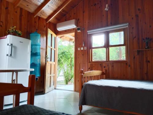 a bedroom with a bed and a refrigerator and a window at Bungalow with access to a large garden near beach in Kemer
