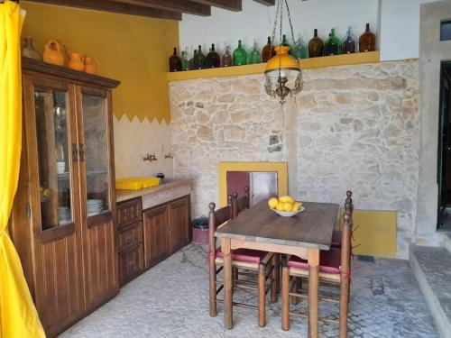a kitchen with a table and chairs and a stone wall at Casinha da Pena - Tomar (Pedreira) in Tomar
