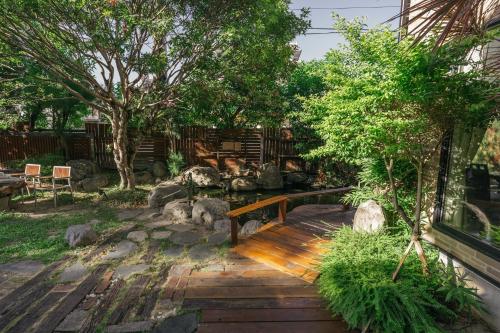 a garden with a wooden bench and trees at 檜木居民宿 - 立案證號 一六三 - 一六八 - 一七零 in Jian