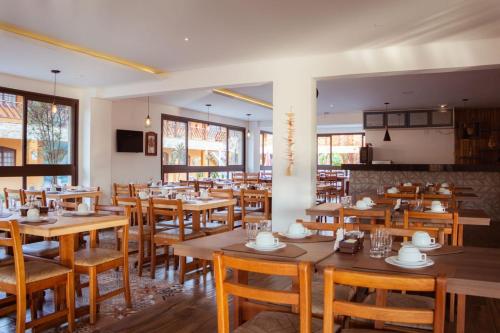 a restaurant with wooden tables and wooden chairs at Hotel Pousada Paradise in Caraguatatuba