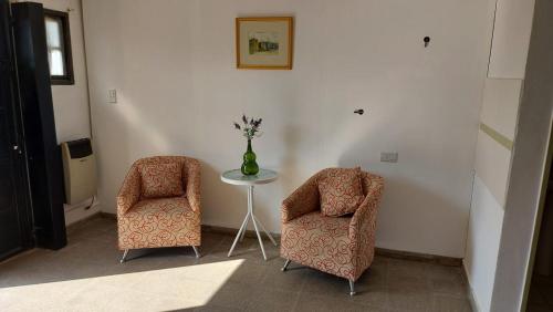 2 Stühle und ein Tisch mit Vase in einem Zimmer in der Unterkunft Departamento Stanza in Villa Mercedes