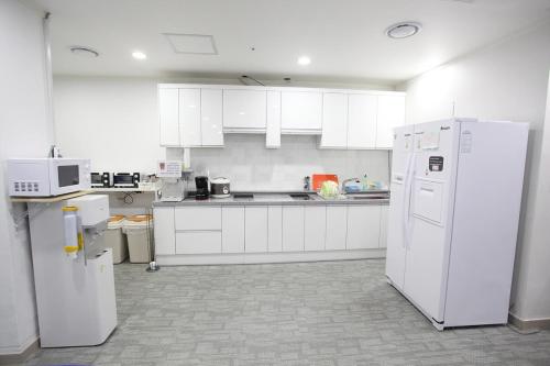 a kitchen with white appliances and white cabinets at Namsan Guesthouse in Seoul