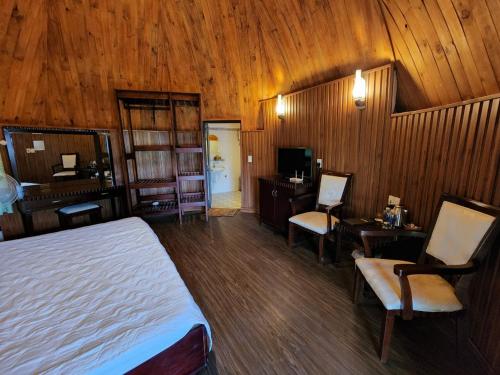 a bedroom with a bed and a desk and a television at Đắk G'lung Bungalow in Bu Yal (1)