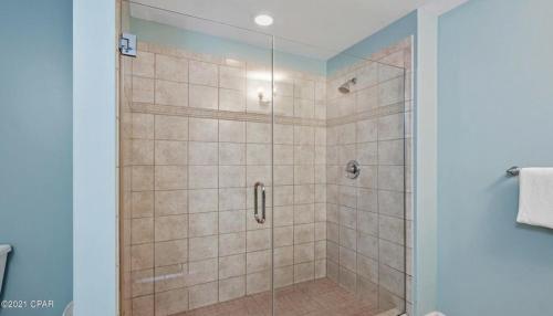 a shower with a glass door in a bathroom at Sterling Breeze 1007 in Panama City Beach