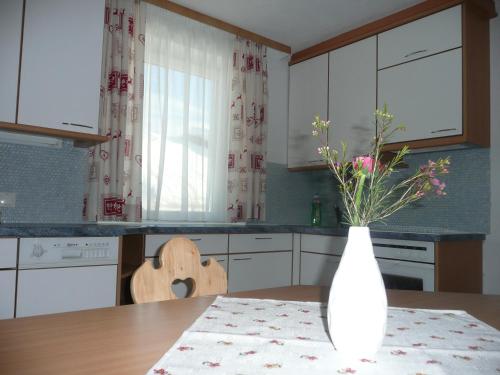 a kitchen with a table and a vase with flowers in it at Appartement Königslehen in Radstadt