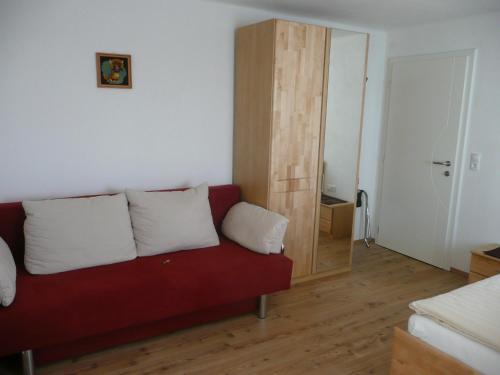 a living room with a red couch with two white pillows at Appartement Königslehen in Radstadt