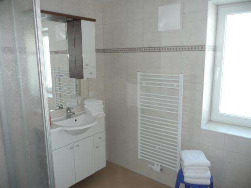 a white bathroom with a sink and a mirror at Appartement Königslehen in Radstadt
