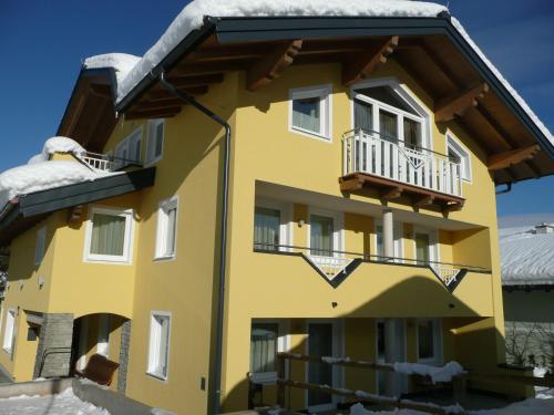 a yellow building with snow on the roof at Appartement Königslehen in Radstadt