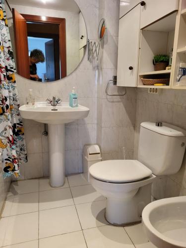 a bathroom with a toilet and a sink and a mirror at Habitación privada in Castro-Urdiales