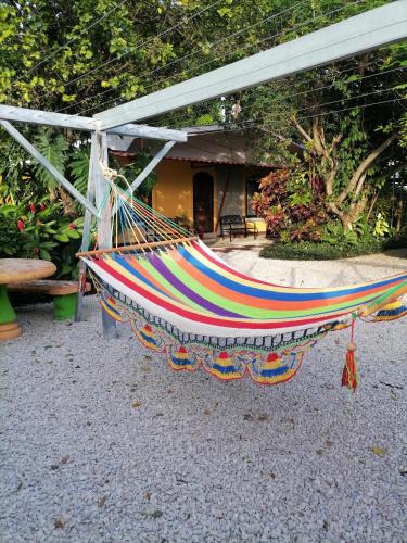 a colorful hammock sitting in front of a building at Villa Gabriela, Casa Tucan in Liberia