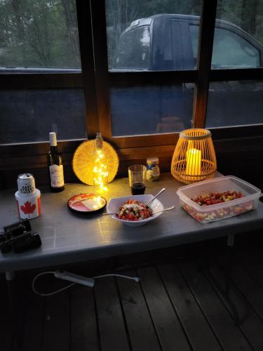 a table with two dishes of food and a light at East Pond View Campsite in Clinton
