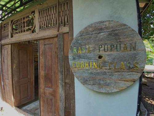 um sinal na lateral de um edifício com uma porta em Bali Jungle Camping by Amerta Experience em Tabanan