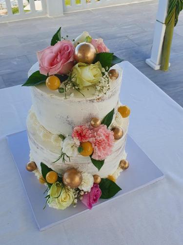a three tiered wedding cake with flowers on it at Villa Bluu Zanzibar in Jambiani