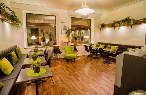 a waiting room with couches and tables and green chairs at H5 Hotel in Helsingborg