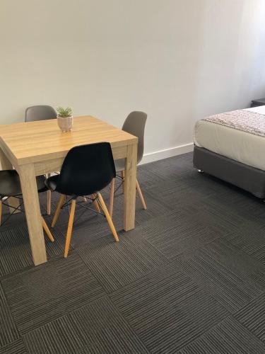 a room with a table and chairs and a bed at Argyle Accommodation in Hobart