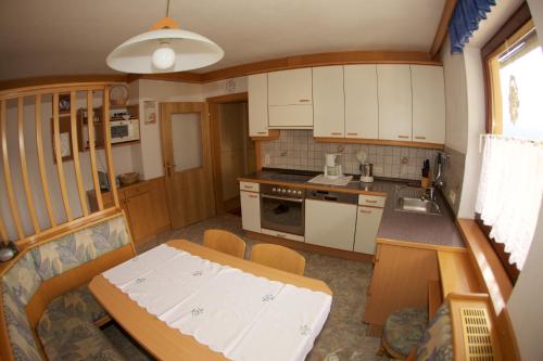 a small kitchen with white cabinets and a table at Haus Stöffler in Reisach