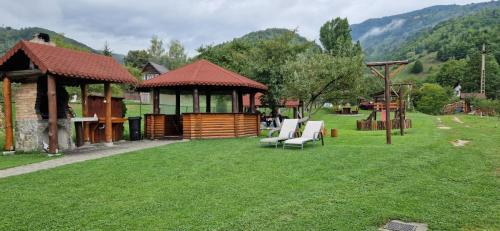 a gazebo with chairs and a gazebo at Pensiunea Denisa Stoian in Moieciu de Jos