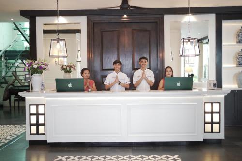 a group of people standing behind a counter with laptops at BYD Lofts - Boutique Hotel & Serviced Apartments - Patong Beach, Phuket in Patong Beach
