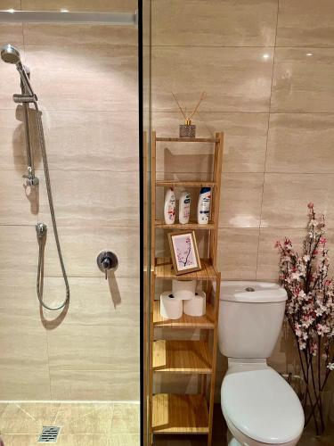 a bathroom with a shower with a toilet and a glass shower at London Chinatown Apartments in London