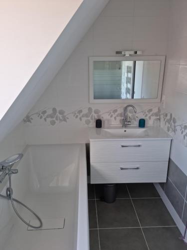 une salle de bain avec un lavabo et un miroir dans l'établissement Longère rénovée sur les hauteurs de Perros-Guirec, à Perros-Guirec