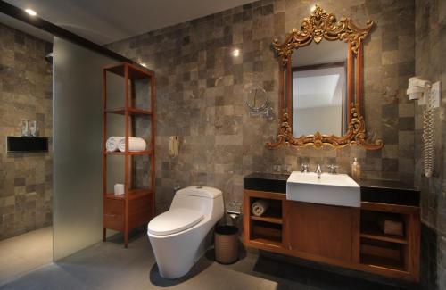 a bathroom with a sink and a toilet and a mirror at Rama Garden Hotel Bali in Legian