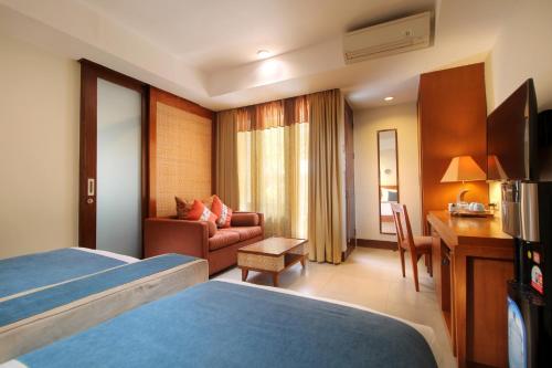 Habitación de hotel con cama y escritorio en Rama Garden Hotel Bali, en Legian