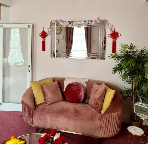 ロンドンにあるLondon Chinatown Apartmentsの鏡付きのリビングルームに茶色のソファ